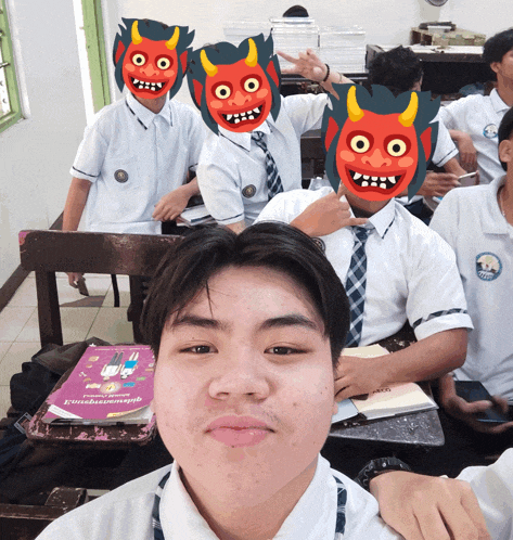 a boy in a classroom wearing a mask with a devil face