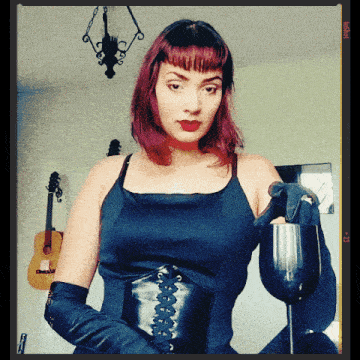 a woman with red hair is holding a wine glass