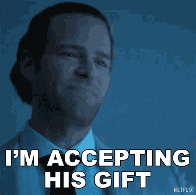 a man in a suit and tie is accepting his gift