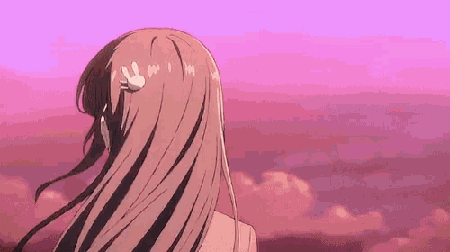 a girl with long hair is looking at a pink sky with clouds