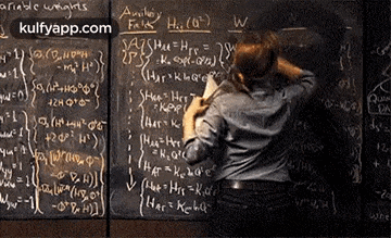 a man is standing in front of a blackboard filled with math problems