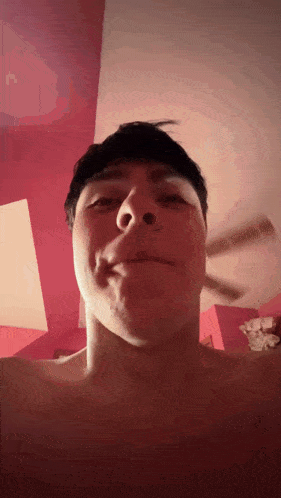 a man without a shirt is making a funny face in front of a fan