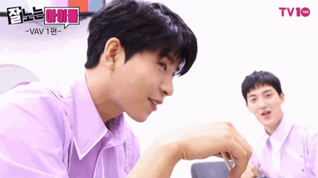 a man in a purple shirt and tie is talking to another man