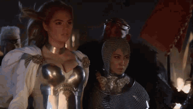 a woman in armor is standing next to another woman