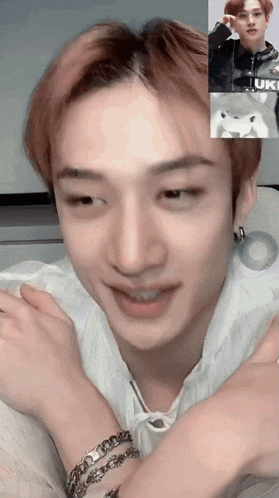 a young man with a bracelet on his wrist is having a video call with another young man