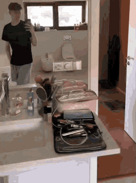 a man taking a selfie in a bathroom mirror