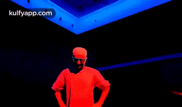 a man wearing glasses and a red hat is making a funny face .