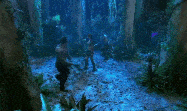 a group of people are standing in a dark jungle