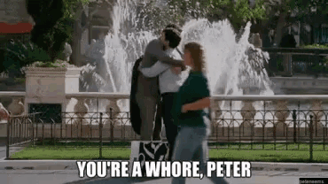 a man and woman are dancing in front of a fountain and the woman is saying you 're a whore peter