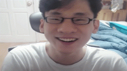 a man wearing glasses and a white shirt is smiling