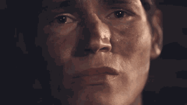a close up of a person 's face with a tear coming out of his eye