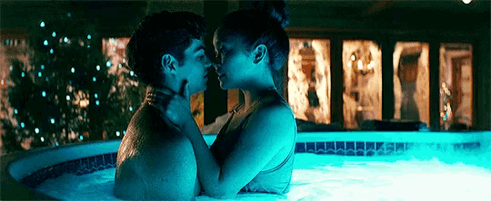 a man and a woman kissing in a hot tub .