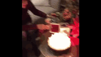 a group of people are gathered around a birthday cake with candles on it