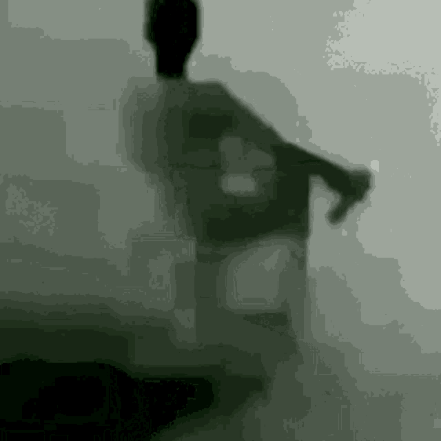 a silhouette of a person standing in front of a wall .