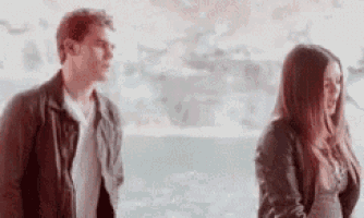 a man and a woman are standing next to each other and talking .