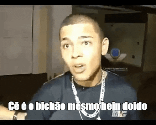a man wearing a chain around his neck is making a funny face and says ce e o bichao mesmohein doido