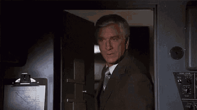 a man in a suit and tie is standing in a doorway and says `` i just want to tell you all good luck . ''
