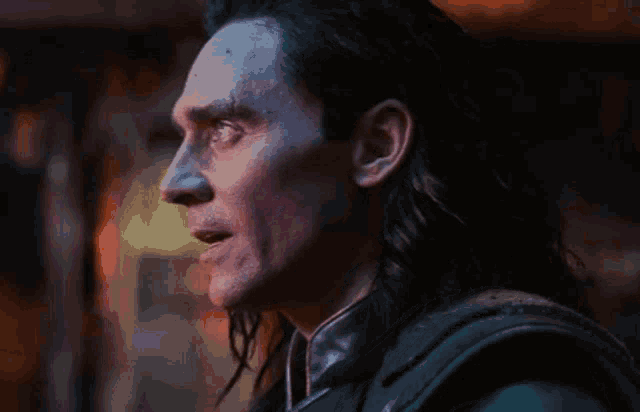 a close up of a man 's face with long hair looking to the side