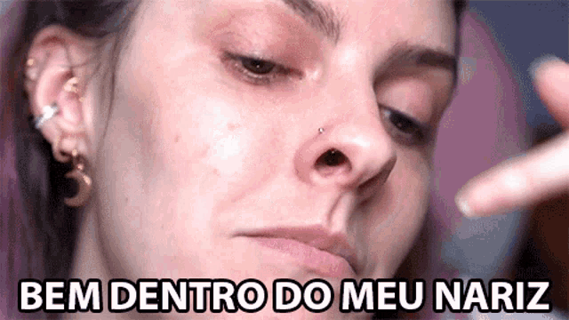 a close up of a woman 's face with the words bem dentro do meu nariz above it
