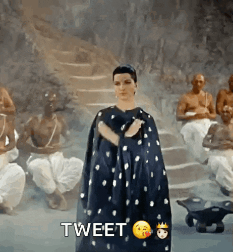 a woman in a black cape is standing in front of a group of men with the word tweet written below her
