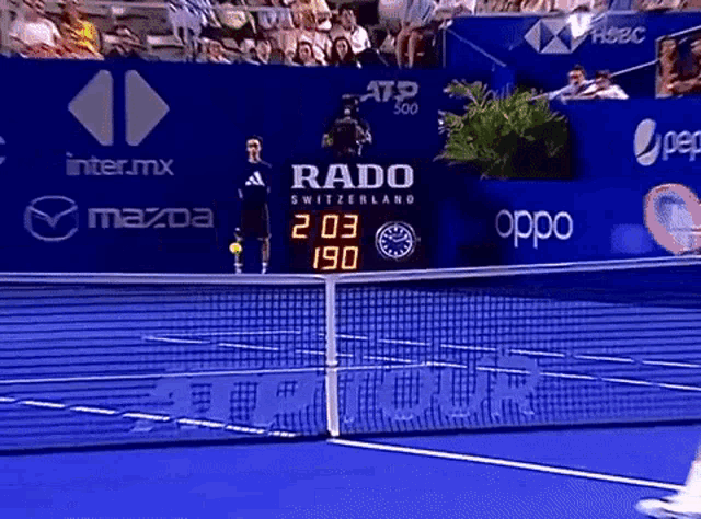 a tennis court with advertisements for rado switzerland and oppo