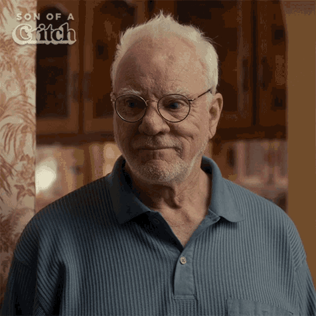 an older man wearing glasses and a blue shirt with the words son of a grifch on the bottom