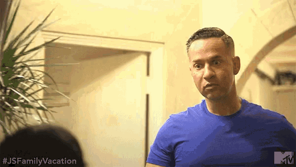 a man in a blue shirt is standing in front of a door with a mtv logo