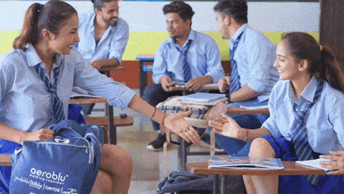 a group of students sitting in a classroom with a bag that says aeroblu on it