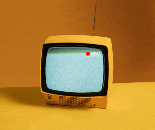 a yellow tv with a red rec sign on the screen