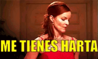 a woman in a red dress stands in front of a sign that says " me tienes harta "