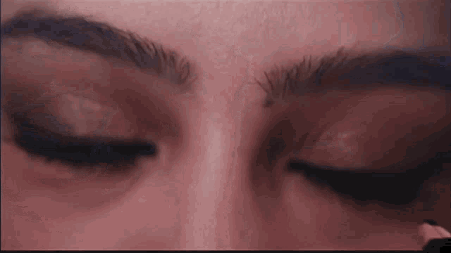 a close up of a woman 's face with her eyes closed