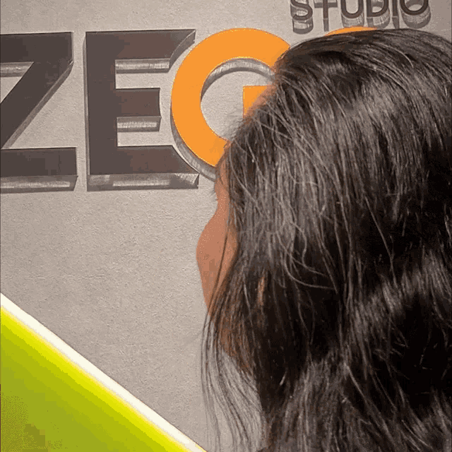 a woman looking at a sign that says zec studio