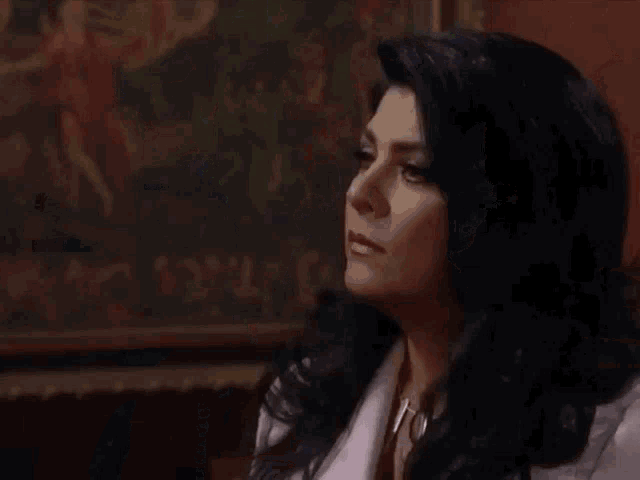a woman in a white coat is standing in front of a door with a painting on it .