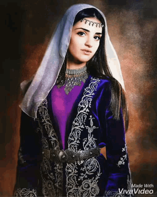 a woman is wearing a purple jacket and a white veil