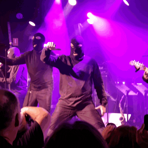 a man in a ski mask sings into a microphone