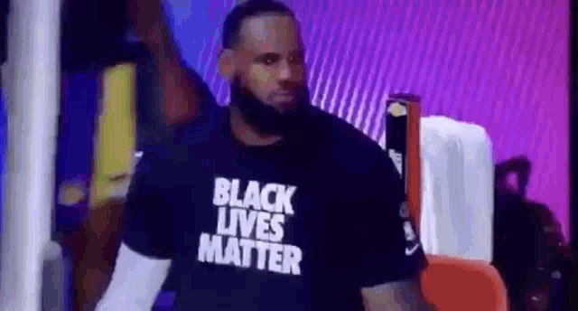 lebron james is wearing a black lives matter t-shirt while sitting in the stands .