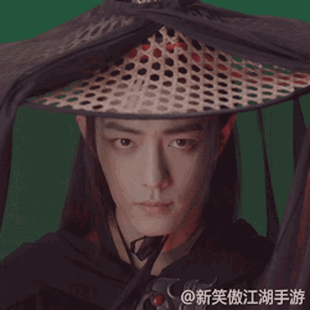 a man with long hair wearing a hat with chinese writing on the bottom