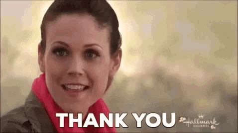 a woman is smiling and saying `` thank you '' while wearing a red scarf .