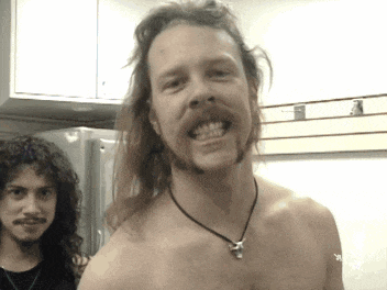 a shirtless man with long hair and a beard is smiling