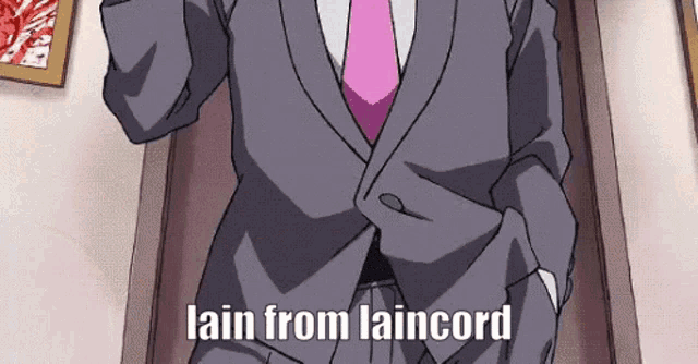 a man in a suit and tie is standing in a doorway with his hands in his pockets and says lain from laincord .