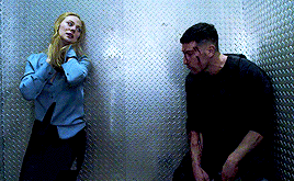 a man and a woman are standing next to each other in a dark room .