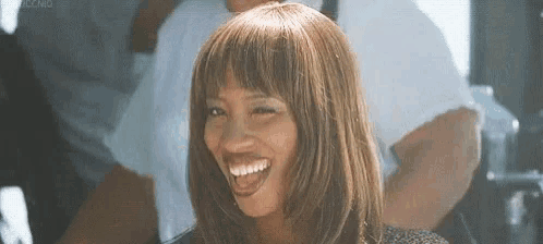 a woman with a wig and bangs is smiling .