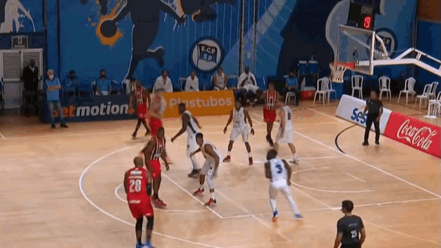 a basketball game is being played on a court with a coca cola banner