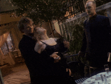 a man kissing a woman 's neck in a movie scene