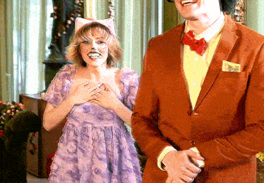 a woman in a cat costume stands next to a man in a suit and bow tie