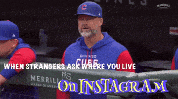a man in a chicago cubs hat is standing in the dugout