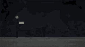 a train is pulling into a station at night with a clock in the background