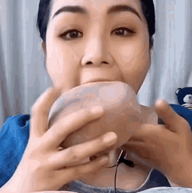 a woman is eating a bowl of food with a microphone in her mouth .