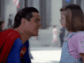 a man in a superman costume is looking at a little girl