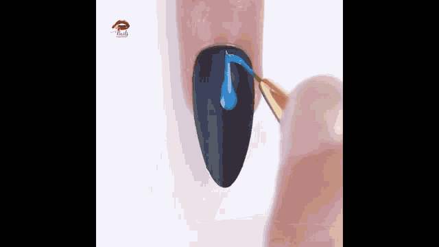 a person is applying blue nail polish to a black nail with a brush .